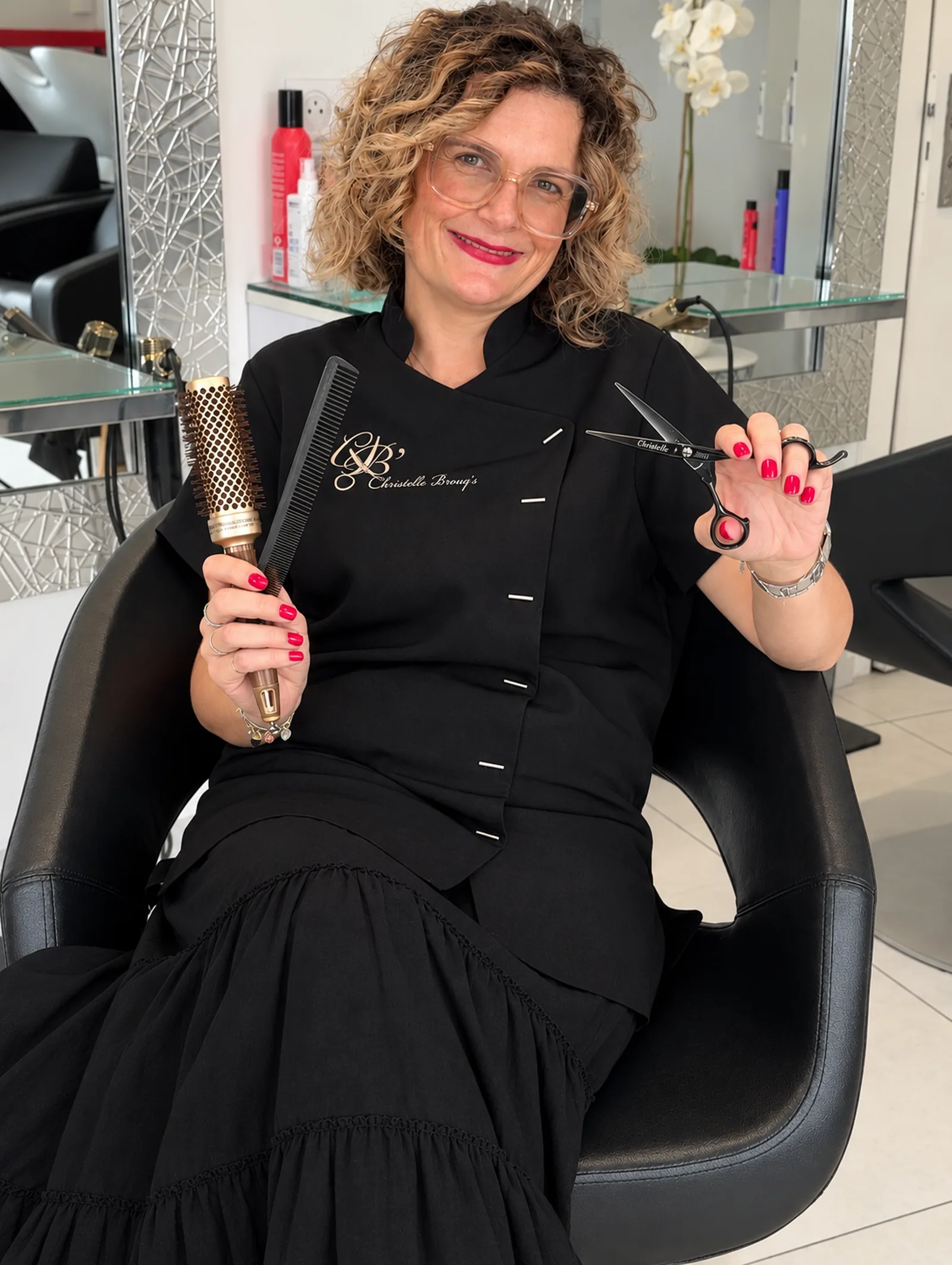 Christelle Brouq dans son salon privé à Anglet, coiffée de boucles naturelles, avec ses ciseaux et son peigne professionnels